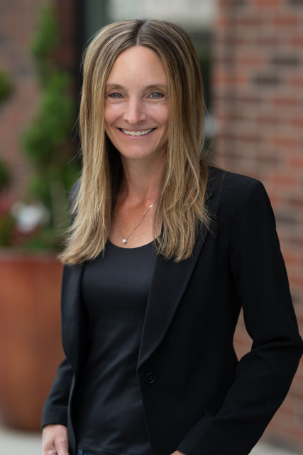 Jennifer Deitchler, Collections Director, in black blazer with straight hair outdoors.